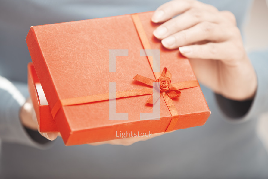 a woman opening a red gift box 