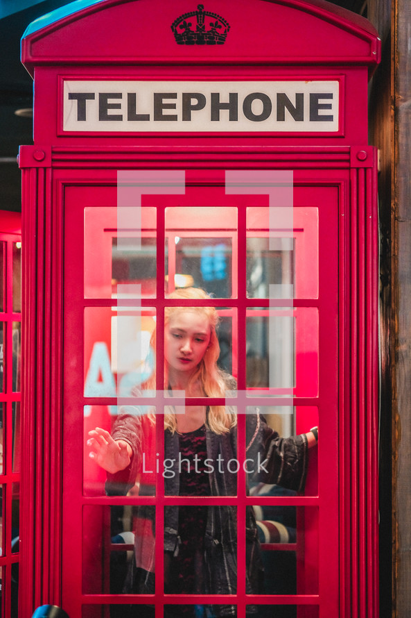 a young woman in a telephone booth 