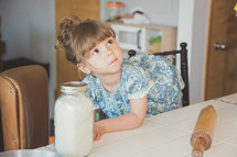 child sitting on a stool in a kitchen 