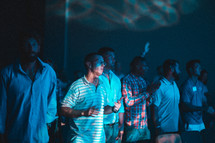 men clapping to music during a worship service 