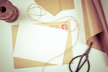 twine, scissors, letter, envelope, brown paper, tags