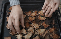 Woman holding baking tray with burnt cookies