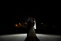 silhouette of a bride and groom in the spotlight 