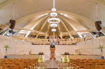 man in prayer in an empty church 