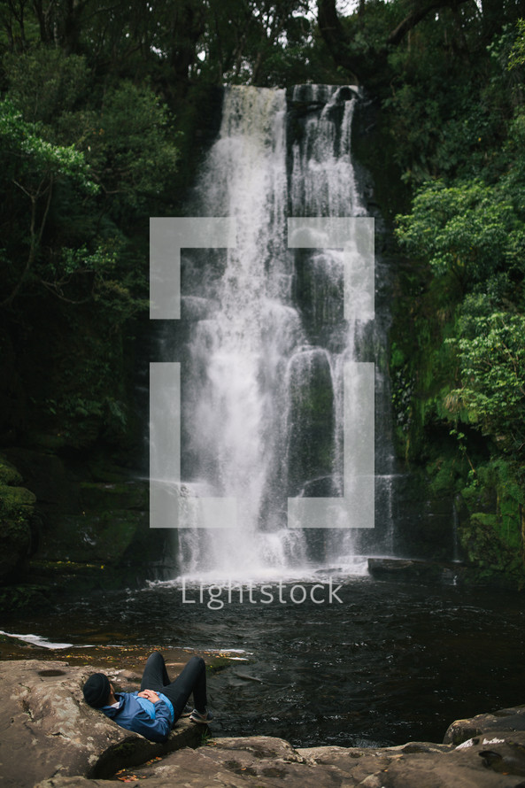 sitting near a waterfall in New Zealand 