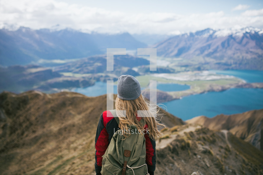 a woman standing on a mountaintop backpacking through New Zealand 