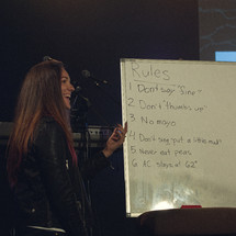 worship leader in front of a whiteboard with random rules 