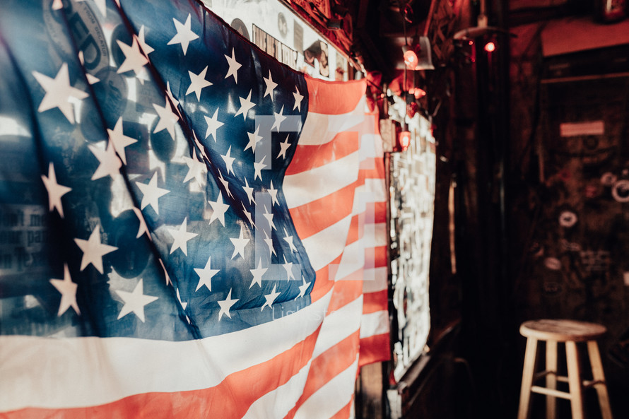 American flag hanging in a window in a bar 