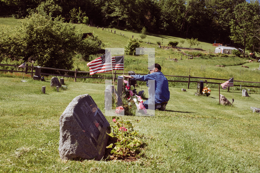 an elderly man visiting a grave on Memorial Day 