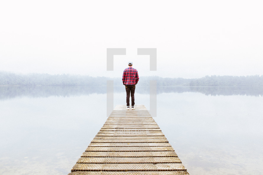 man standing at the end of a pier 