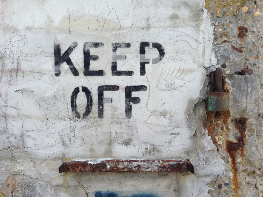 "Keep Off" sign on a wall.