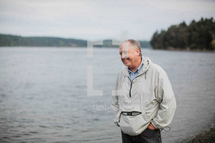 a man standing by a lake shore 