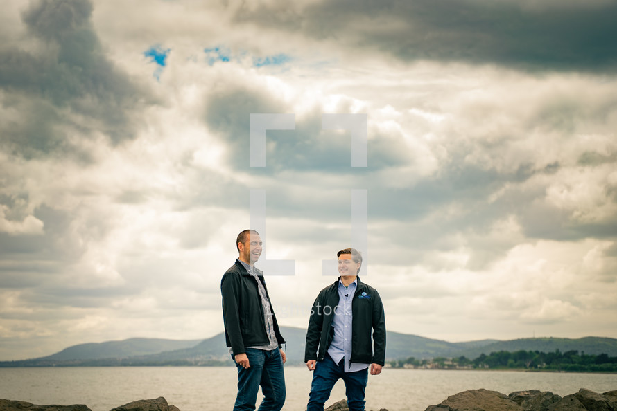two men standing on a mountaintop outdoors 