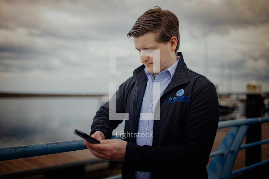 a man talking on a phone at a harbor 