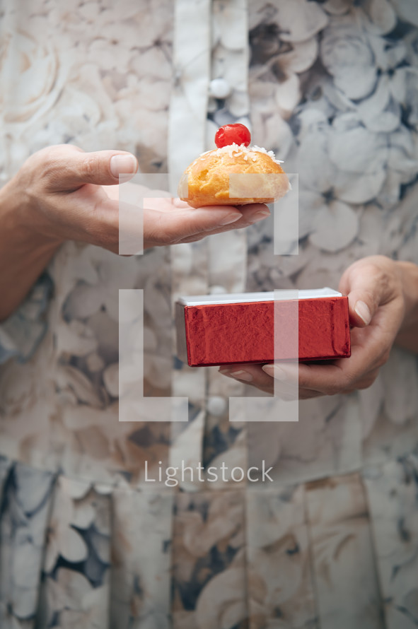 Woman holding Christmas eclair at home