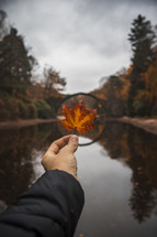 circular bridge and person holding up a fall leaf 