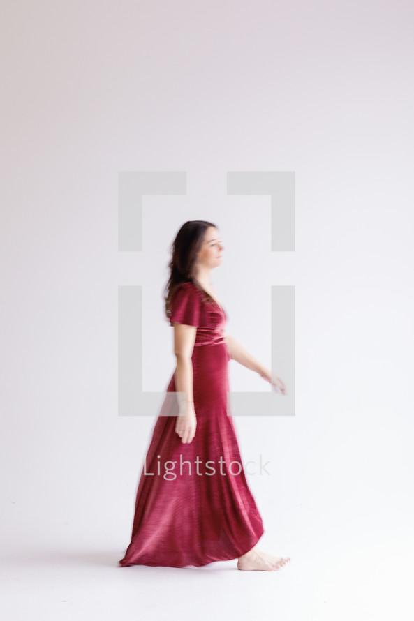 Woman walking in a dress on a white background 