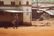 Muslim African woman walking in a dusty village in the Ivory Coast, West Africa