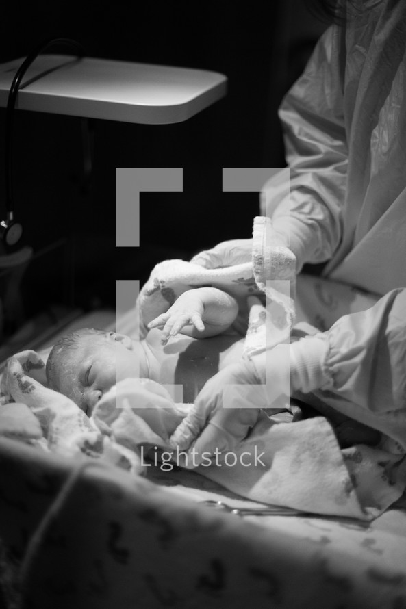 Nurse handling a newborn infant.