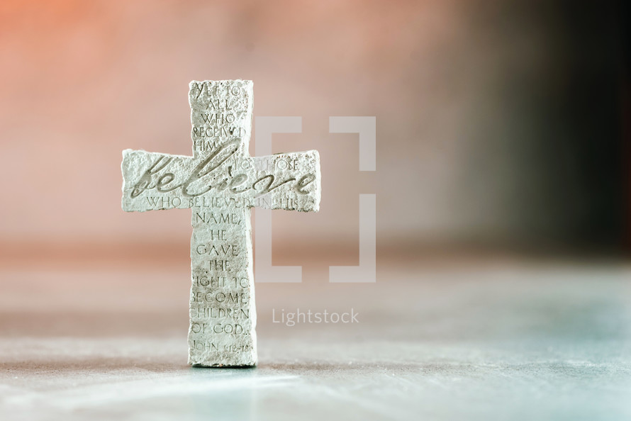 Stone cross with inscription Believe.