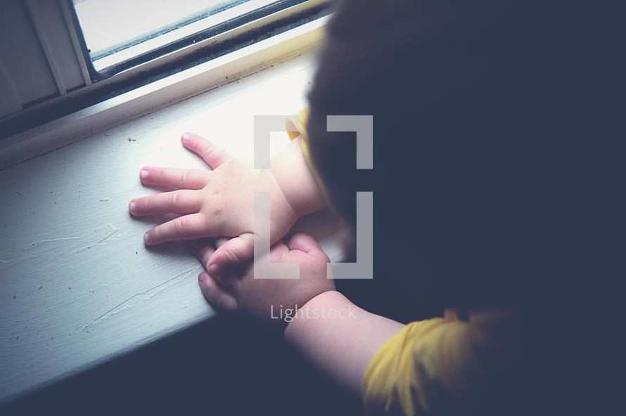 toddler hands on a window sill 