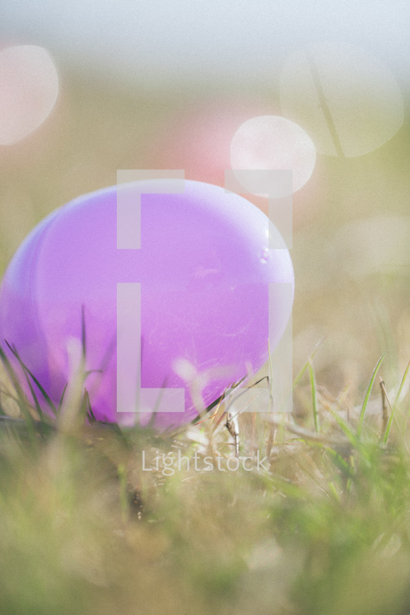 pink plastic Easter egg in the grass