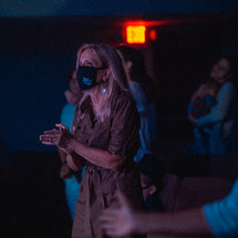 a woman wearing a mask during a worship service 