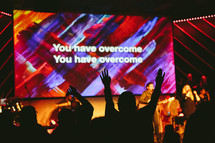 silhouette of raised hands at a contemporary worship service 