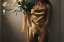 a woman in a yellow dress holding a bouquet