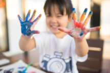 little girl with paint on her hands 