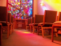 Church aisle and sunlight through a stained glass window 