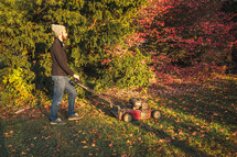 a man mowing the grass in fall 