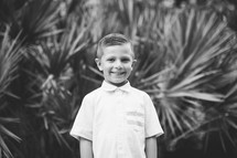 smiling boy in front of palm trees 