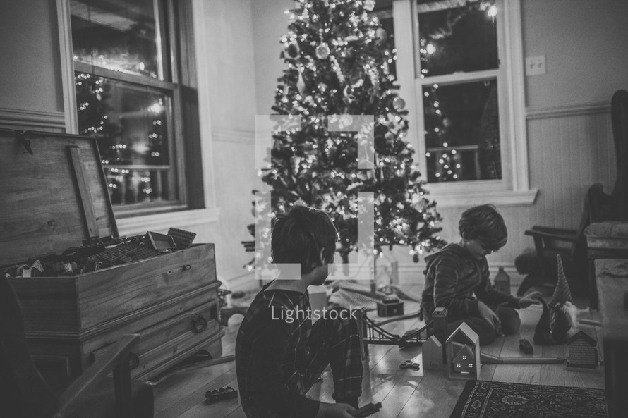 children playing with toys around a Christmas tree 
