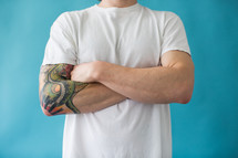 a torso of a man in a white t-shirt and a sleeve tattoo 