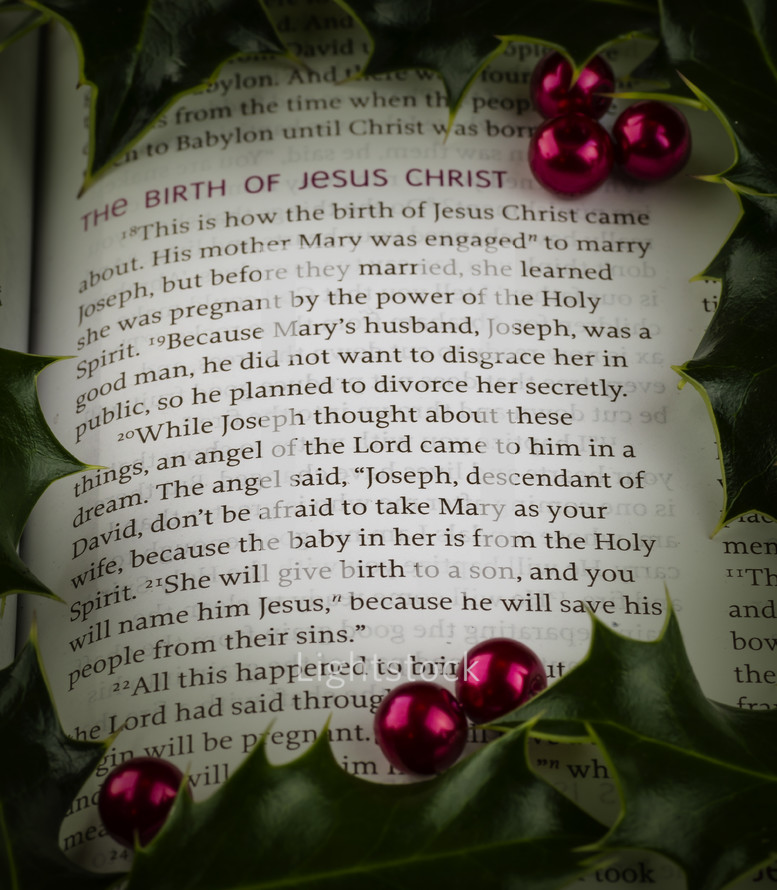 Close-up Christmas scripture Birth of Christ, Matthew 1:18-21 with holly and berries