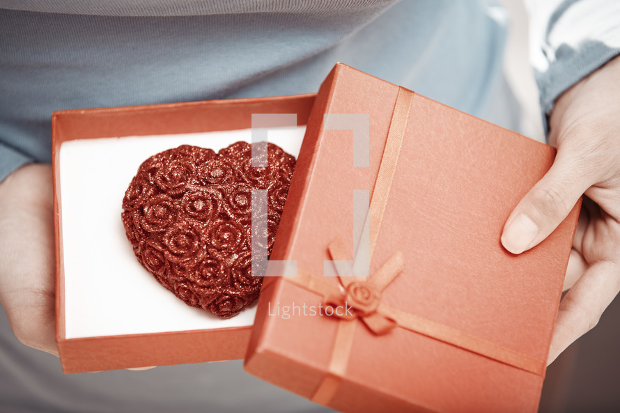 woman opening a gift box with a heart inside 