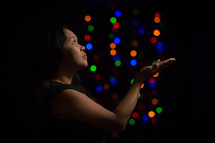a woman looking up to God in worship and colorful bokeh lights 