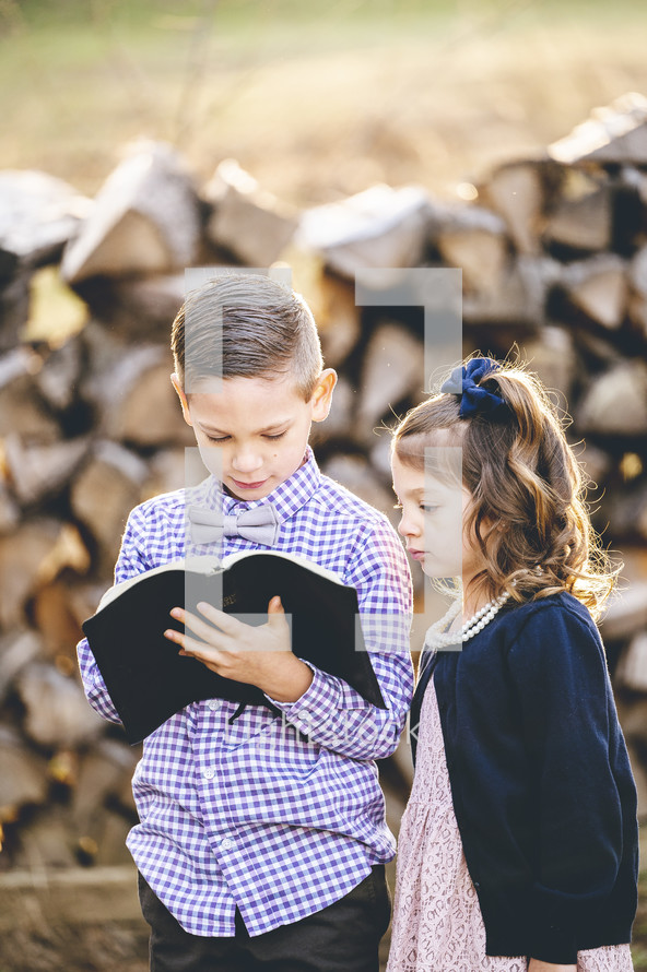 brother and sister standing together holding a Bible on Sunday morning 