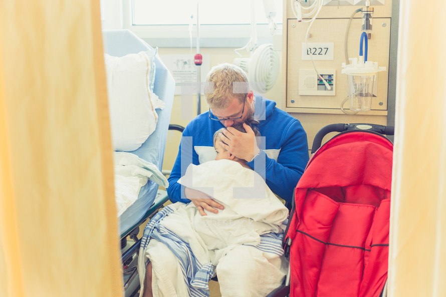 a father comforting his son in a hospital gown in a hospital 