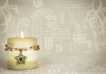Christmas candle with star and jewels, cream text background