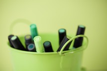 green markers in a bucket 