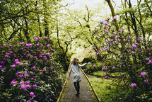 a girl walking on a path in the botanical gardens