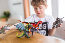 kids playing with toy dinosaurs and dragons 
