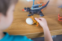kids playing with toy dinosaurs and dragons 