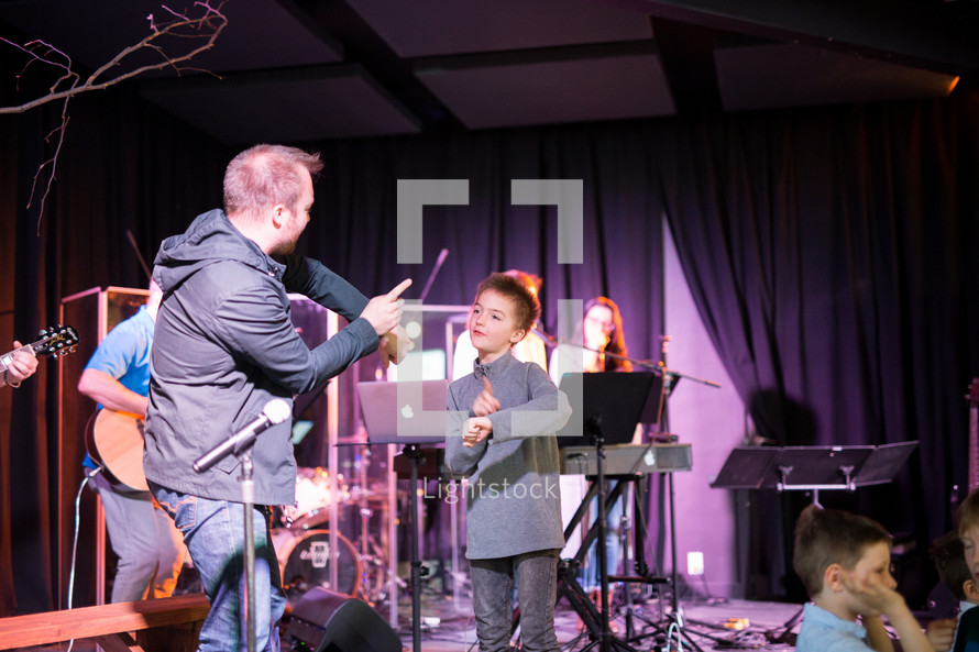 musicians performing on stage and a child on stage 
