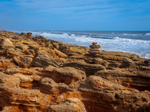 stacked rocks on a rocky beach 