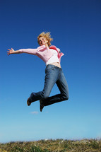 a woman jumping up in the air celebrating 