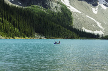 trees on a mountainside and canoe on a mountain lake 
