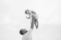 father lifting up his daughter 